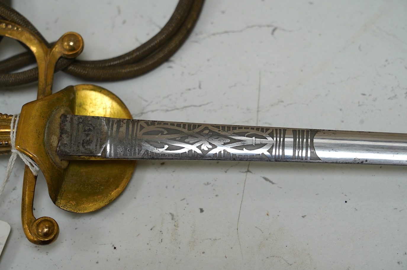 A late Victorian court sword gilt brass hilt with crown on guard, beaded edges, bullion dress knots, in its leather scabbard, blade 78cm. Condition - fair to good